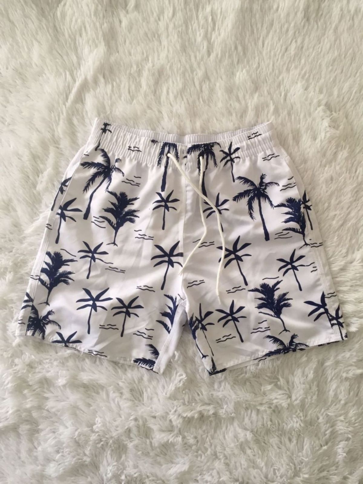 Weiße Nylonshorts mit Kokospalmenmotiv.